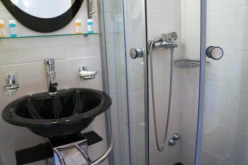 a bathroom with a black sink and a shower at Captain's House Hotel in Skala