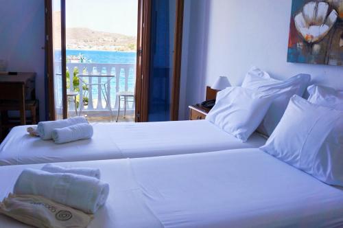 Duas camas brancas num quarto com vista para o oceano em Captain's House Hotel em Skala