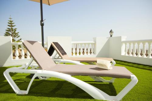two lounge chairs and an umbrella on a lawn at Casa Alba - By AZ Rentals in Tías