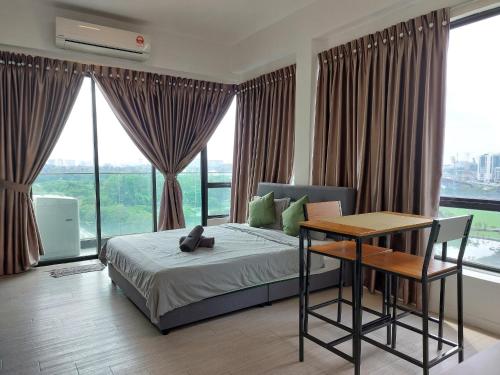 a bedroom with a bed and a table and windows at Inspired Homes @ PJ The Grand Sofo in Petaling Jaya