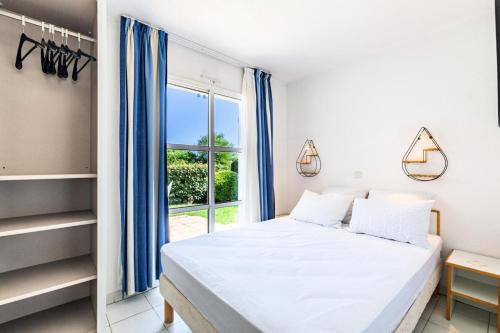 une chambre avec un lit et une grande fenêtre dans l'établissement Résidence le Village de Cap Esterel - maeva Home - Appartement 2 pièces 6 personnes - Sélection MAE-8594, à Saint-Raphaël