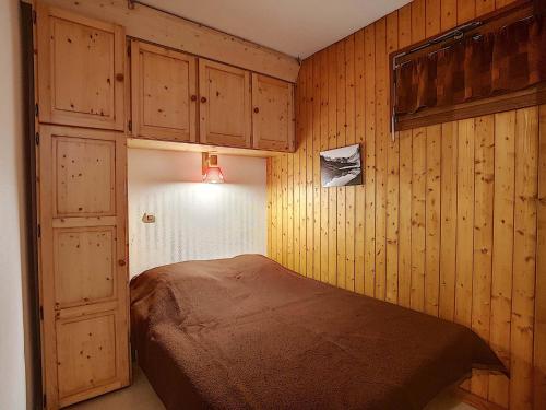 a bedroom with a bed in a room with wooden walls at La Résidence RS0224 Bat.2 in La Clusaz