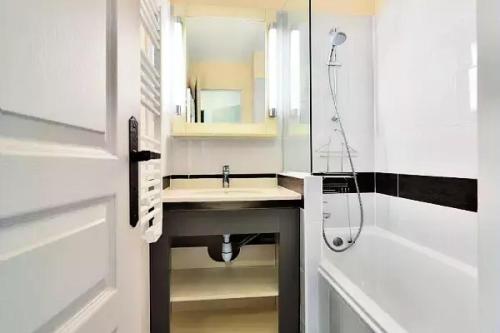 y baño blanco con lavabo y ducha. en Résidence Cannes Villa Francia - maeva Home - Appartement 3 pièces 6 perso 674, en Cannes