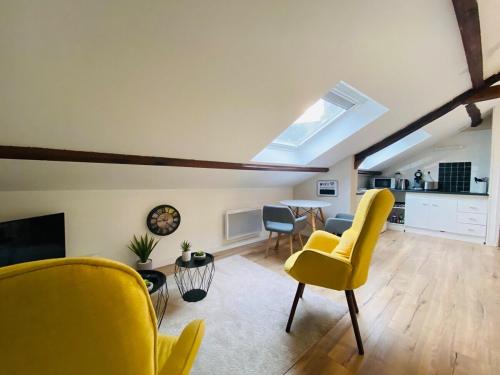 un salon avec des chaises jaunes et une table dans l'établissement Casa Balzac – T2, à Angers
