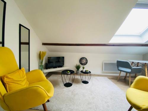 - un salon avec 2 chaises jaunes et une télévision dans l'établissement Casa Balzac – T2, à Angers