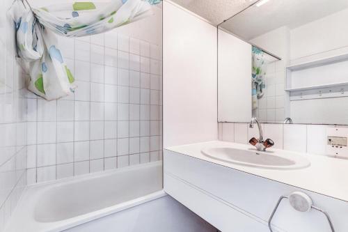 La salle de bains blanche est pourvue d'un lavabo et d'une baignoire. dans l'établissement Résidence Port Bourgenay - maeva Home - Appartement 2 pièces 4 personnes - Sélection MAE-5854, à Talmont-Saint-Hilaire