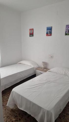 twee bedden in een kamer met witte muren bij Key Reig in Almussafes