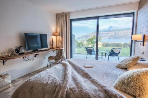 - une chambre avec un lit et une grande fenêtre dans l'établissement Villa Caroline, Lac d'Annecy, à Duingt
