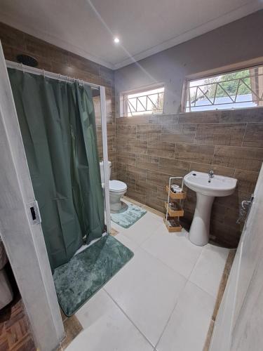 a bathroom with a shower and a toilet and a sink at Berlydai Guest Accomodation in Secunda