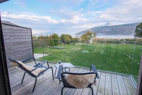 a porch with two chairs and a view of a golf course at Villa Caroline, Lac d'Annecy in Duingt