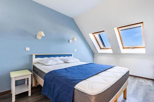 une chambre avec un lit avec des murs et des fenêtres bleus dans l'établissement Port du Crouesty Cap'Océan - maeva Home - Appartement raffiné 3 pièces 6 personnes - Sélection - super Home MAE-2204, à Arzon