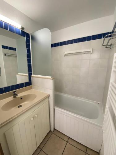 une salle de bain avec un lavabo, une baignoire et un miroir dans l'établissement Résidence Bleu Marine - maeva Home - Appartement 2 pièces 4 personnes - Confort MAE-2214, à Lacanau