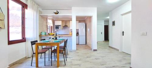 a kitchen and dining room with a table and chairs at National Trust Beach Apartment in Santiago del Teide
