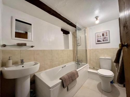 a bathroom with a sink and a tub and a toilet at Bluebell Cottage in Ross on Wye