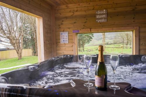 a bottle of champagne and two wine glasses in a hot tub at Pure relaxation at it's finest, offering moments of harmony and tranquillity - Sauna & Hot tub in Shanklin