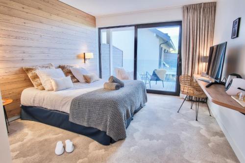 a bedroom with a bed and a large window at Villa Caroline, Lac d'Annecy in Duingt