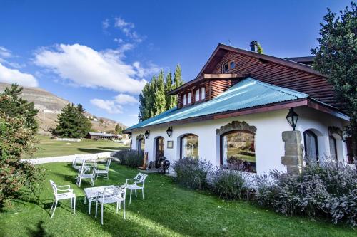 ein Haus mit Stühlen und Tischen im Hof in der Unterkunft Kau Yatún Hotel Boutique in El Calafate