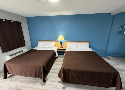 Duas camas num quarto com paredes azuis em Budget Inn em Thomasville