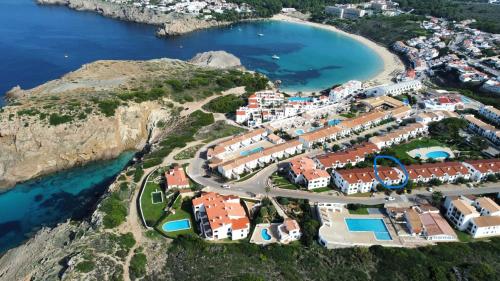 an aerial view of a resort near the ocean at Stunning sea views apartment, pool, 5 min walk to beach, Winner of 2025 Travellers Choice award in Arenal d'en Castell