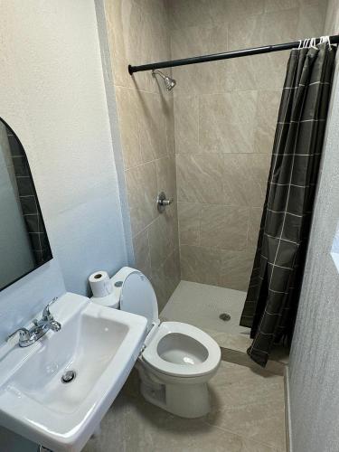 a bathroom with a toilet and a sink and a shower at Budget Inn in Thomasville