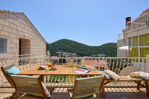 einen Holztisch und Stühle auf dem Balkon in der Unterkunft Luxe Retreat in Lapad - Seaside in Dubrovnik