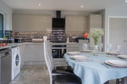 a kitchen with a table with plates and wine glasses at Pure relaxation at it's finest, offering moments of harmony and tranquillity - Sauna & Hot tub in Shanklin