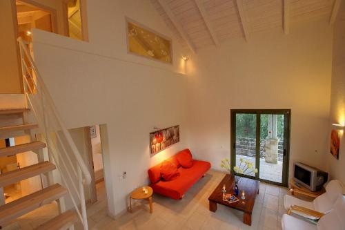 ein Wohnzimmer mit einem roten Sofa und einer Treppe in der Unterkunft Villa Telina Ideales Resort in Kefalonia