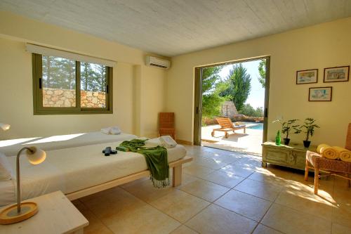 Schlafzimmer mit einem Bett und Blick auf einen Innenhof in der Unterkunft Villa Porfyra Ideales Resort in Kefalonia