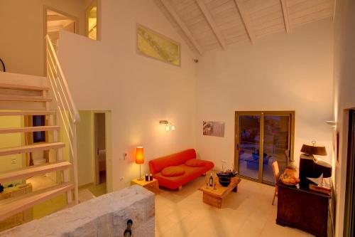 a living room with a red couch and a staircase at Villa Asterias Ideales Resort in Kefallonia