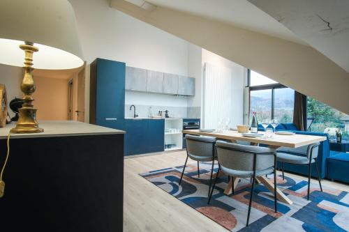 a kitchen with blue cabinets and a table and chairs at Villa Caroline, Lac d'Annecy in Duingt