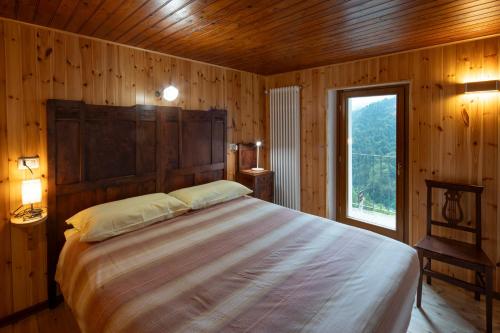 a bedroom with a large bed in a wooden room at Casa Gemma in Rimella