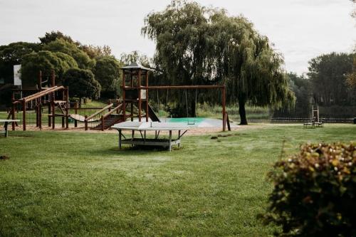 een park met een speeltuin met een tafel in het gras bij Japandi Wellness met hottub & sauna in Ewijk