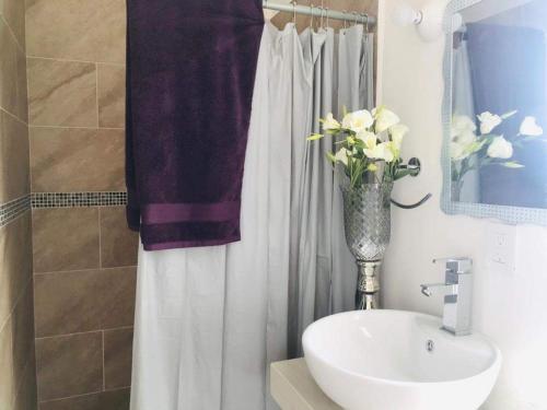 a bathroom with a sink and a vase of flowers at Casa del Lago in Veracruz