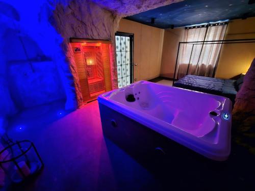 ein Badezimmer mit einer großen Badewanne mit violetter Beleuchtung in der Unterkunft suite 43 in Terrasini