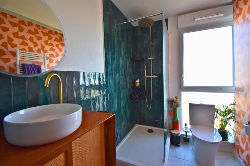 La salle de bains est pourvue d'une baignoire, d'un lavabo et d'une douche. dans l'établissement Le Belvédère Parisien, à Aubervilliers