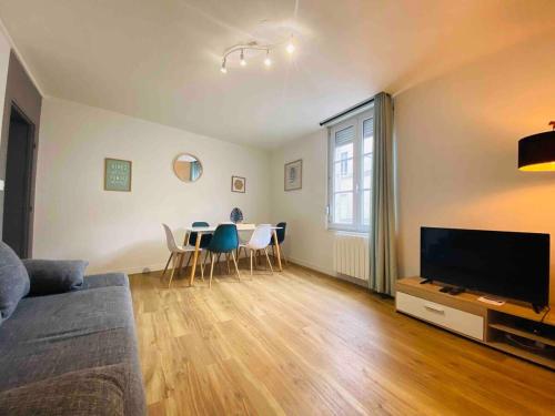 een woonkamer met een bank en een tafel met stoelen bij Casa Balzac – T3 in Angers