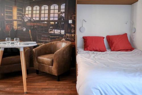 une chambre avec un lit, une chaise et une table dans l'établissement Atypique en plein cœur de Toulon, à Toulon