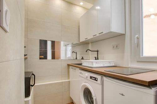 - une cuisine blanche avec un lave-linge et un évier dans l'établissement Atypique en plein cœur de Toulon, à Toulon