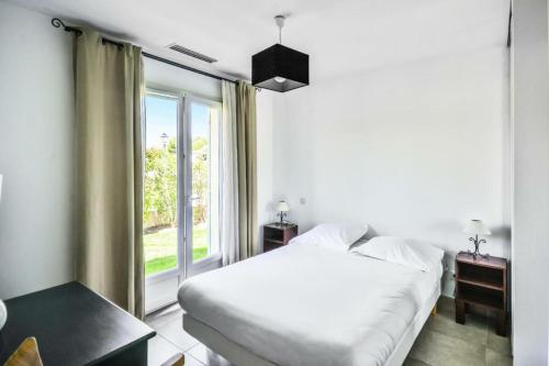 1 dormitorio con cama y ventana grande en Les Mas et Villas de Pont Royal en Provence - maeva Home - Villa de charme 5 074, en Mallemort