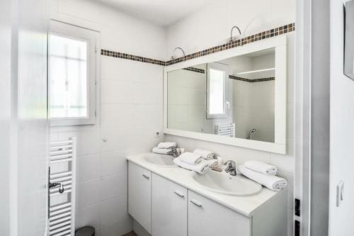 Baño blanco con lavabo y espejo en Les Mas et Villas de Pont Royal en Provence - maeva Home - Villa de charme 5 074, en Mallemort