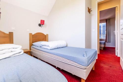 2 camas individuales en una habitación con alfombra roja en Résidence Le Hameau du Lac - maeva Home - Maison 3 pièces 6 personnes - Co 364 en Marciac