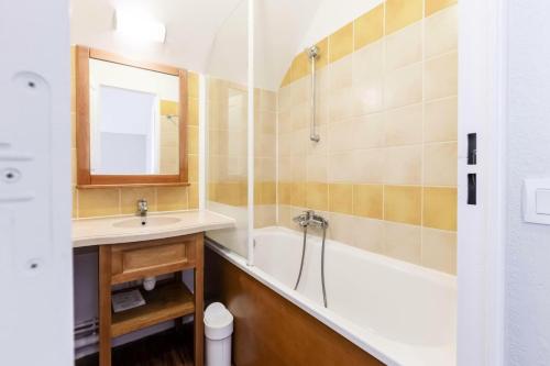 une salle de bain avec un lavabo, une baignoire et un miroir dans l'établissement Résidence Le Hameau du Lac - maeva Home - Maison 3 pièces 6 personnes - Confort MAE-6364, à Marciac