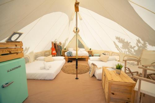 a room with two beds in a tent at Kampaoh Playa Troenzo in Celorio