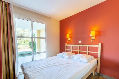 une chambre avec un lit et une grande fenêtre dans l'établissement Résidence le Village de Cap Esterel - maeva Home - Appartement 2 pièces 5 personnes - Confort MAE-6094, à Saint-Raphaël