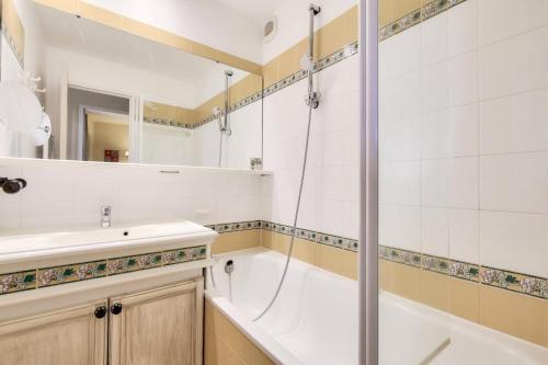 une salle de bain avec une baignoire, un lavabo et une douche dans l'établissement Les Appartements aux Restanques du Golfe de St Tropez - maeva Home - Appartement belle vue mer 3 pièces 7 personnes - Sélection MAE-1794, à Grimaud