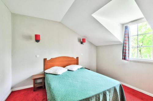 une chambre avec un lit vert et une fenêtre dans l'établissement La résidence du Lac - maeva Home - Maison 2 pièces 5 personnes - Sélection MAE-4244, à Monflanquin