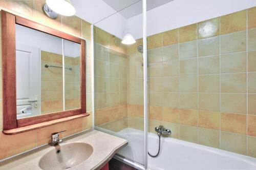 une salle de bain avec un lavabo, une baignoire et un miroir dans l'établissement La résidence du Lac - maeva Home - Maison 2 pièces 5 personnes - Sélection MAE-4244, à Monflanquin