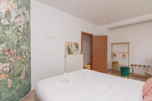 Un dormitorio con una cama blanca y una pintura en la pared en Luxurious Apt For 6 Ppl Near The Center of Athens, en Atenas
