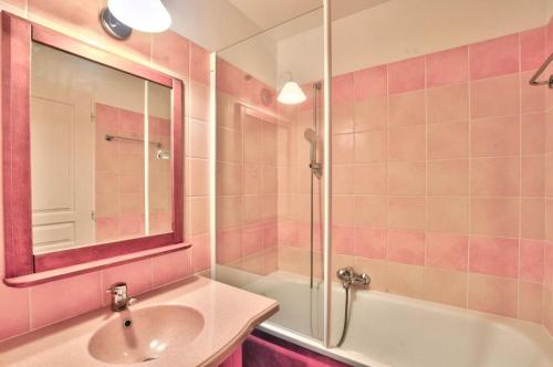 La salle de bains rose est pourvue d'un lavabo et d'une douche. dans l'établissement La résidence du Lac - maeva Home - Appartement 2 pièces 5 personnes - Sélection MAE-4254, à Monflanquin