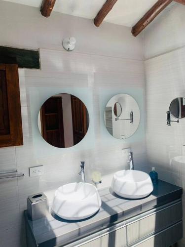 a bathroom with two sinks and two mirrors at Spain style country house in Cajica in Cajicá